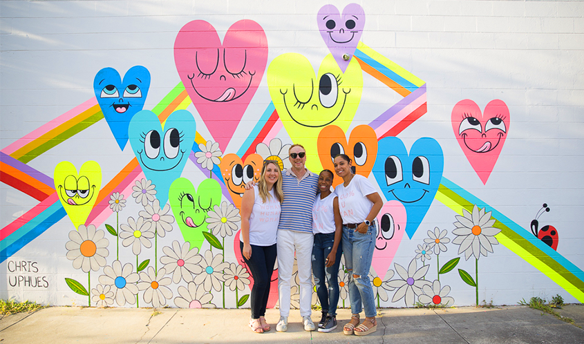 Chris Uphues and team standing infront of finished fluorescent mural