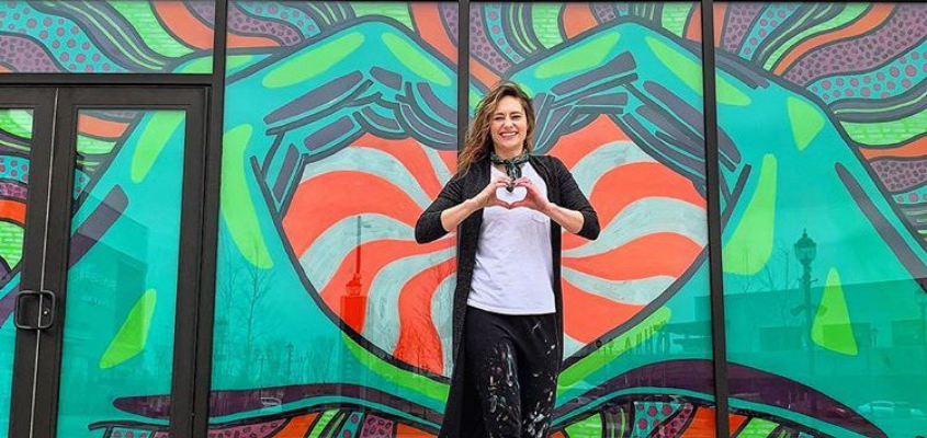 Lisa Quine standing in front of her love hands window splash